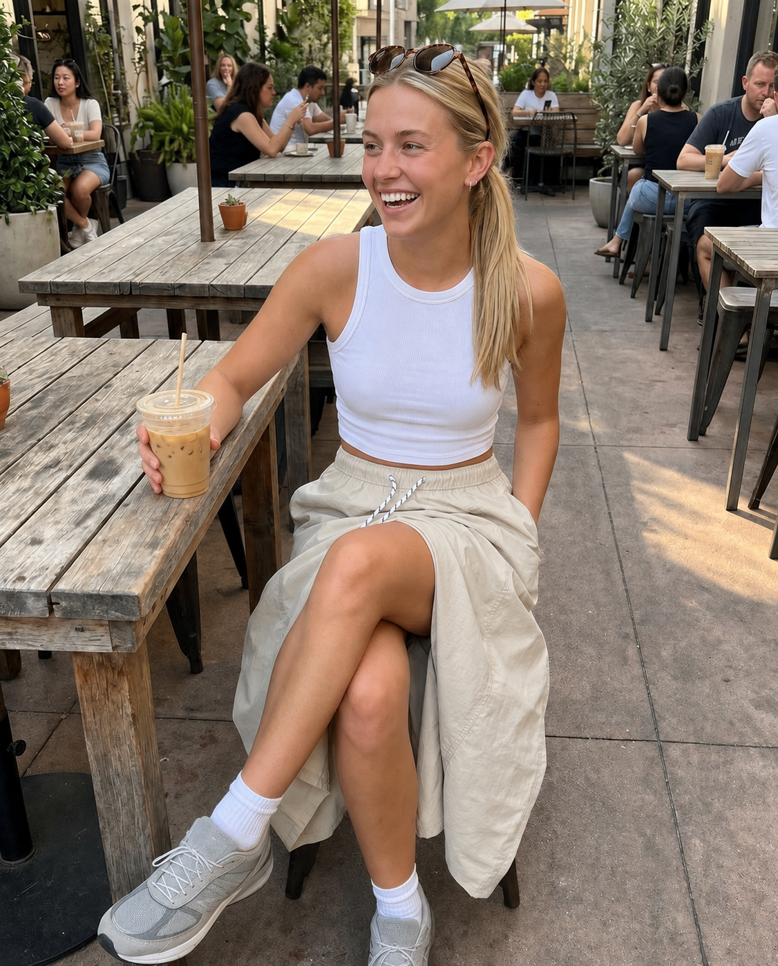 Lifestyle view of Pretty Hours lightweight khaki drawstring midi skirt at an outdoor cafe
